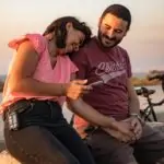 Mujer sonriente apoyando la cabeza en el hombro de un hombre sonriente