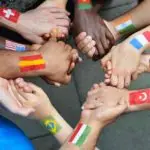 hands joined with different country flags painted on the wrist to signify unity