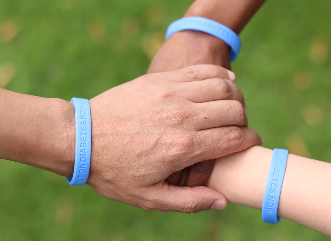 three hands crossed wearing blue wristbands