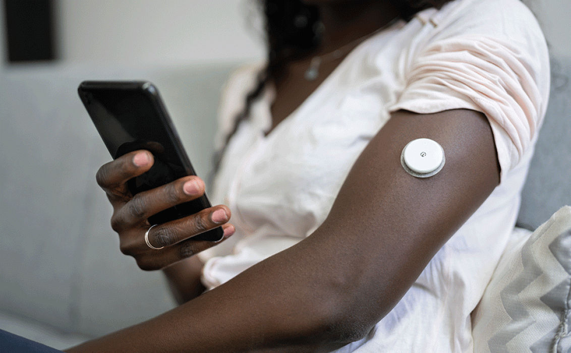 African woman with CGM sensor and smartphone app
